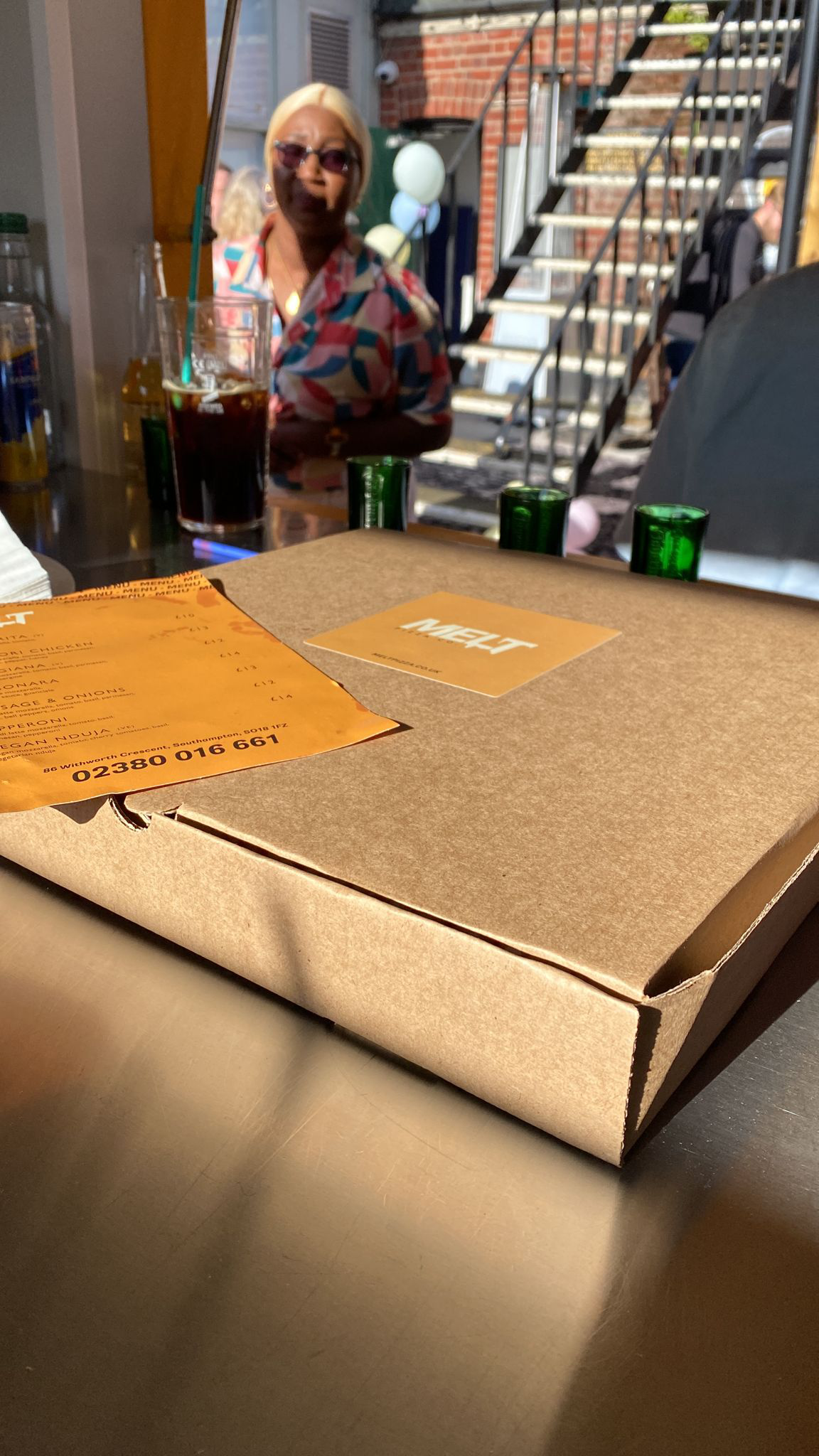 At Melt Pizza, a customer picks up his stone-baked pizza